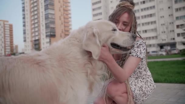 Νεαρό κορίτσι με dreadlocks παίζει με το σκυλί στο δρόμο — Αρχείο Βίντεο