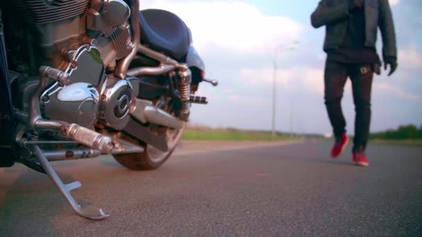 Motorkář kráčí po silnici ke svému motocyklu vrtulníku — Stock video