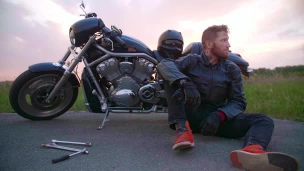 Motorcykeln gick sönder, han sitter och väntar på hjälp. — Stockvideo