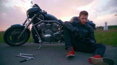Yol kenarındaki motosikletli. Bozuk bir helikopterle destek çağırıyorlar.