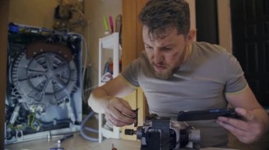Genç ev hanımı bozuk çamaşır makinesini nasıl tamir edeceğini bilmiyor.