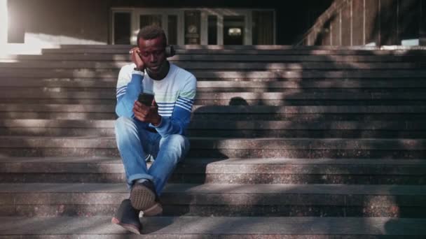 黑人年轻人用耳机听音乐 — 图库视频影像