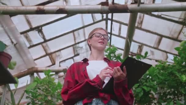 Blonde Girl Goes to Work on a Flower Greenhouse — 图库视频影像