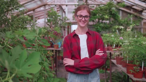 Портрет молодого работника теплицы, в которой выращиваются цветы и растения, девушка-инспектор — стоковое видео