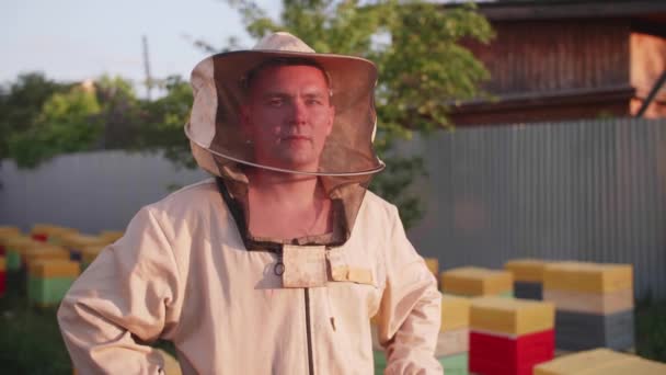 Portret młodego właściciela pasieki, na której hoduje pszczoły i wyciąga miód — Wideo stockowe