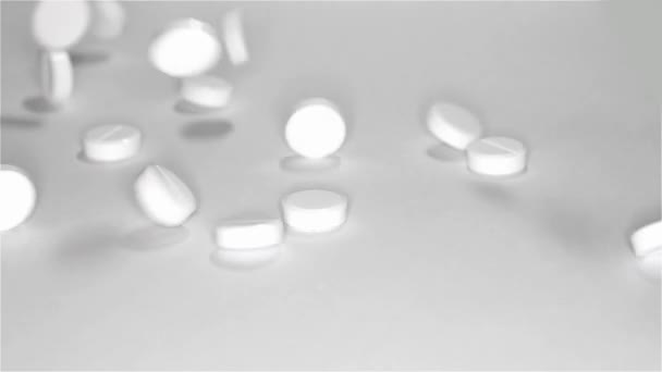 Fehér tabletták szétszóródott az asztalon — Stock videók
