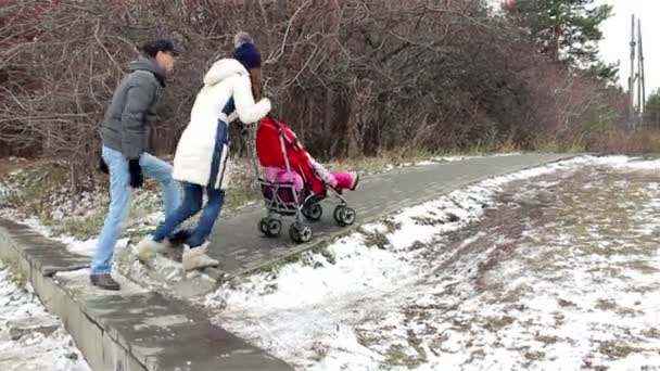 Familia joven con un niño camina por la calle — Vídeo de stock