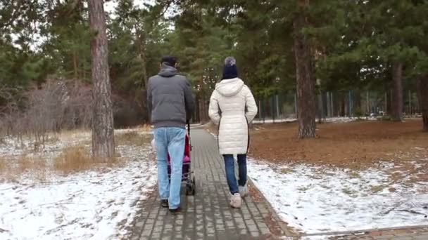 Jeune famille avec un enfant marche dans la rue — Video