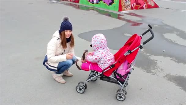 Молодая мать грустит дочь в детской коляске — стоковое видео