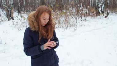 Telefon ile kış ormanda kız iwalking