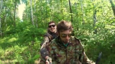 Orman yoluyla dört binen iki adam