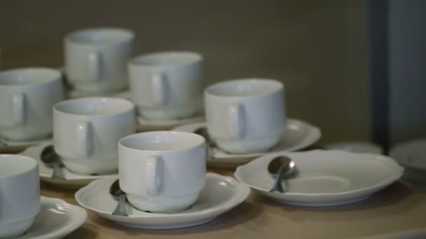 Mnoho bílé čajové šálky v tabulce — Stock video