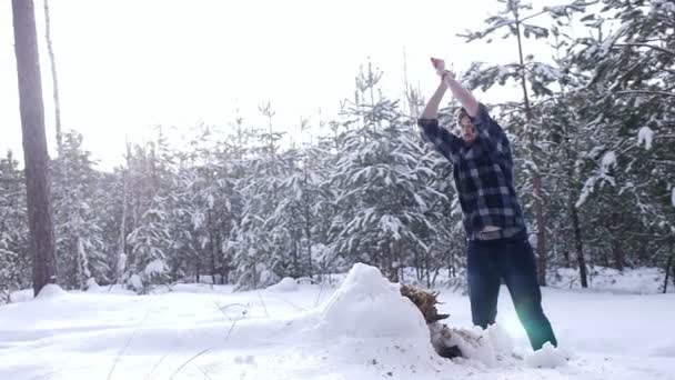 Houthakker hakken AX om brandhout te snijden in het winter bos — Stockvideo