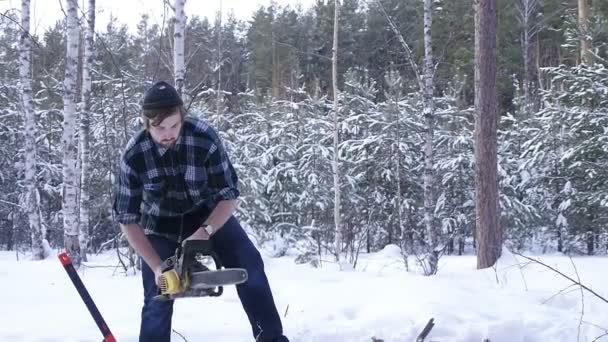 겨울 눈 덮인 숲에서 목재를 톱질 하는 목재 잭 전기 톱 수동 — 비디오