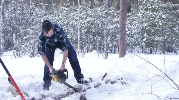 冬の雪の森で木材を見る木材ジャックチェーンソーマニュアル — ストック動画