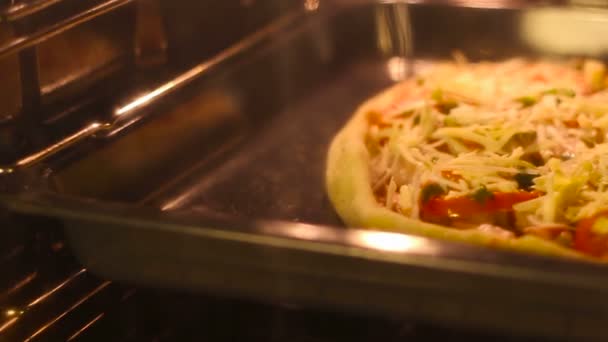 クローズ アップのキッチンで自宅のオーブンでピザを調理 — ストック動画