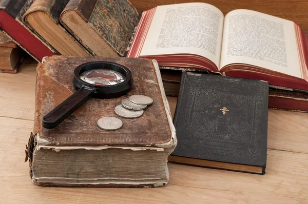 アンティーク書籍、虫眼鏡、テーブルの上の銀のコイン — ストック写真