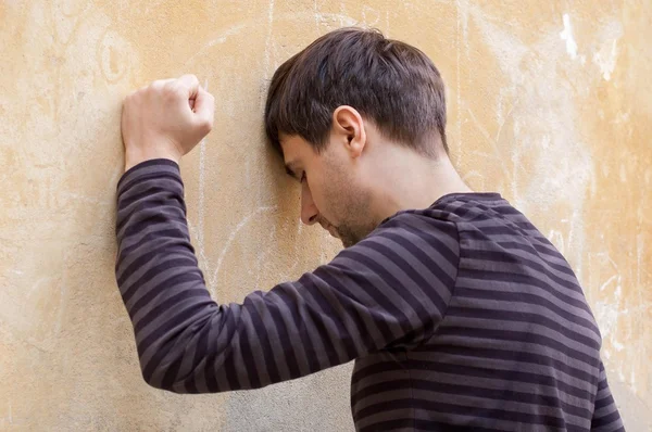 depresif adam başı bir duvara yaslanmış