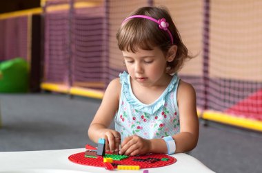 Tablo ve oynanan renk tasarımcı oturan küçük kız.