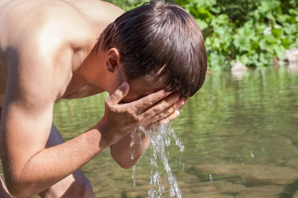 Man washing face in river — Stock Photo, Image