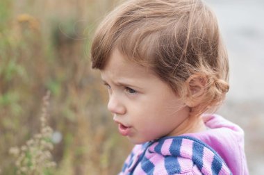 Üzgün küçük kız bir yana görünüyor