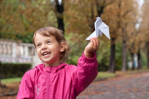 Menina segurando uma pomba de papel — Fotografia de Stock