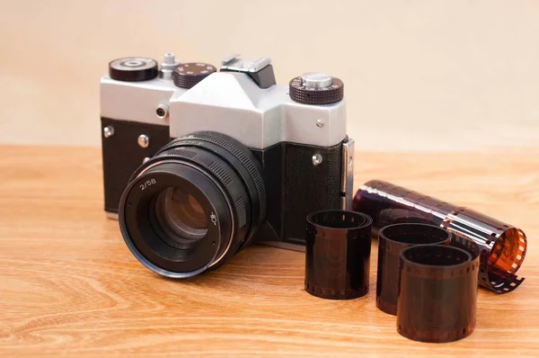 Εκλεκτής ποιότητας φωτογραφική μηχανή και τα αρνητικά στο ξύλινο τραπέζι — Φωτογραφία Αρχείου