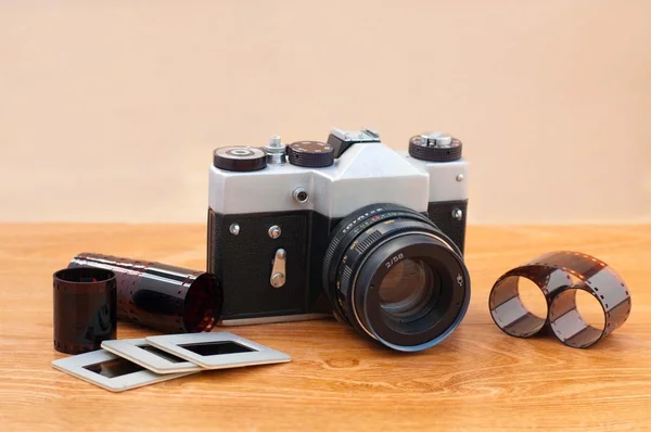 Vintage camera, slides and negatives on wooden table — Stock Photo, Image