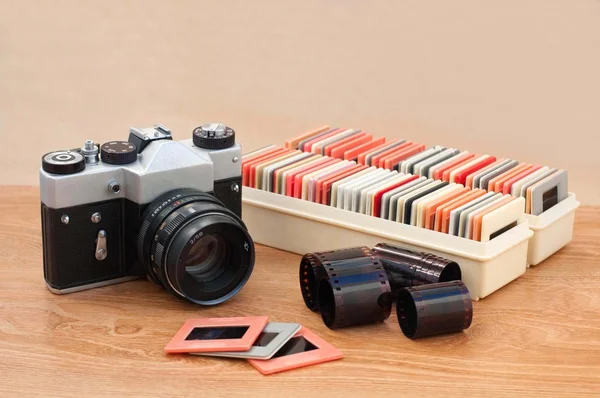 Cámara vintage, diapositivas y negativos sobre mesa de madera — Foto de Stock