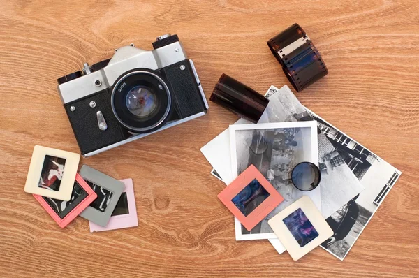 Vintage camera, slides, photos and negatives on wooden background — Stock Photo, Image