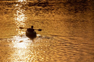Gün batımında gölde iki kürekçi - tanımlanamaz.