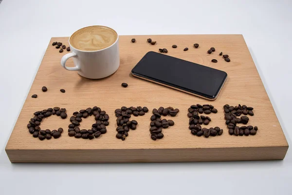 任何工人的必需品 咖啡和通信 一杯开胃的咖啡 一部电话和咖啡豆 被安排到咖啡这个词中 — 图库照片
