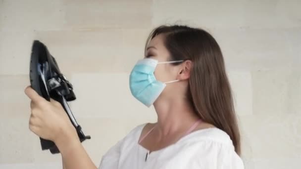 Молодая модница в медицинской маске держит новые черные мокасины. Девушка довольна покупкой и обнимает их и улыбается. Девушка получила подарок на день рождения или праздник 8 марта — стоковое видео