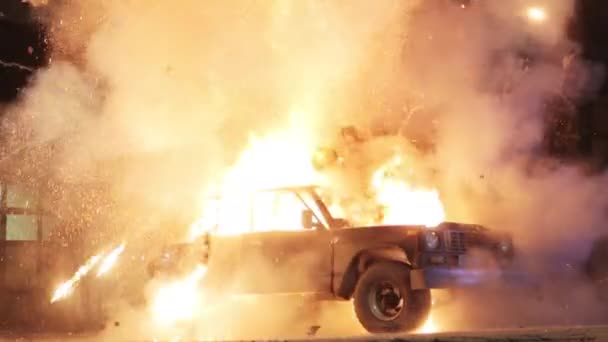 Das Auto explodiert, Motorhaube und Dach werden abgerissen. Ein schwarzer Geländewagen wird in der Nacht auf einer Straße in der Stadt von einer riesigen orangefarbenen Flamme einer Explosion auseinandergerissen. Das Auto explodiert durch eine Bombe oder einen Granateinschlag. — Stockvideo