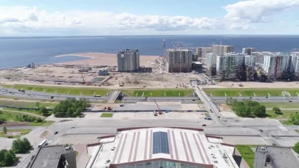 Sint-Petersburg. Rusland. De vlucht van het dak van het gebouw via de snelweg met auto 's naar de alluviale gebieden waarop bedrijfscentra en woongebouwen worden gebouwd. — Stockvideo