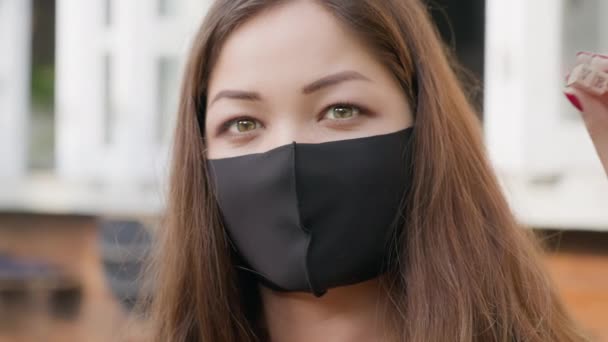 Asiatisches Mädchen mit Maske in Pandemiezeiten, die das Wort LIEBE mit Holzkabinen macht. Valentinstag erschossen. Frau drückt ihre Gefühle schweigend in Briefen aus. Sprachloses Geständnis mit Zeichen — Stockvideo