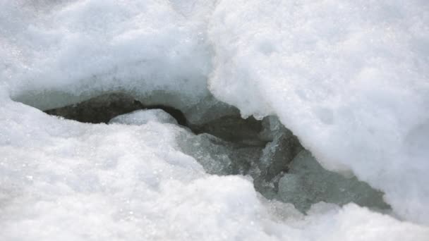 Primer plano de una grieta en los témpanos de hielo blanco de un glaciar ártico. El agua, el océano vivo y su aliento salen a través de una grieta en el témpano de hielo. Aumento del nivel del agua del océano mundial. Calentamiento global — Vídeo de stock