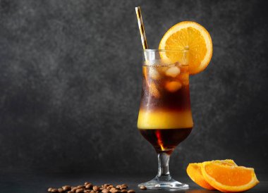 Bir bardak parlak yaban arısı ya da koyu arkaplanda buzlu portakal suyu ve espresso kahvesinden yapılmış kurutulmuş arı kokteyli. Karışık kahve.. 