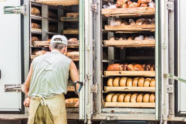 raflar çeşitli ekmek dolu. Adam onları alır