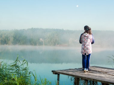 romantik genç çift ayakta ahşap köprüde suya genişletilmiş.