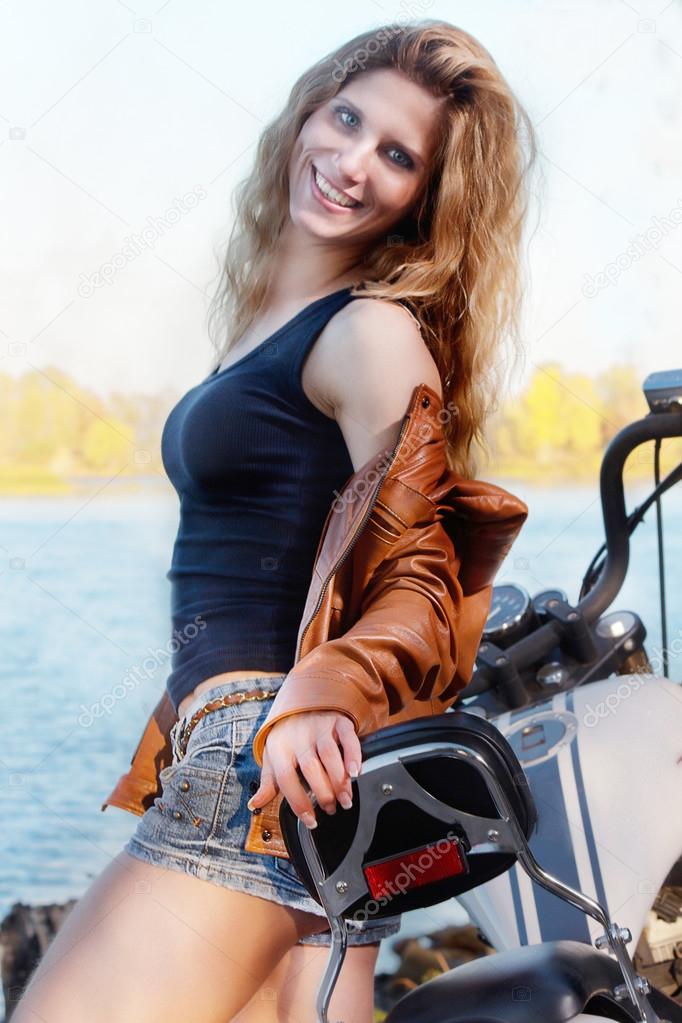 Portrait of young beautiful sexy lady with long hair wearing leather jacket  and short shorts sitting on motorcycle Stock Photo by ©ostser7 123604444