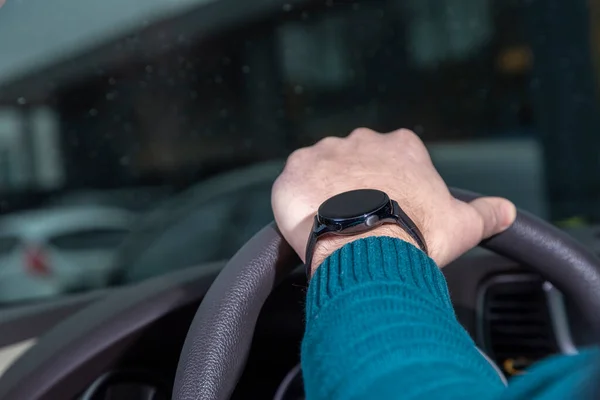 Человек держит руль, часы на его руке, Galaxy Watch3 — стоковое фото