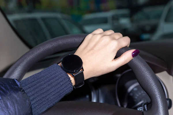 Женская рука держит руль, часы на его руке, Galaxy Watch3 — стоковое фото