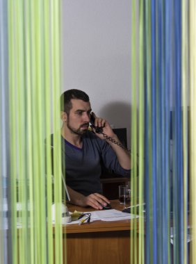 Telefonla konuşurken neşeli genç işadamı dikey görüntü