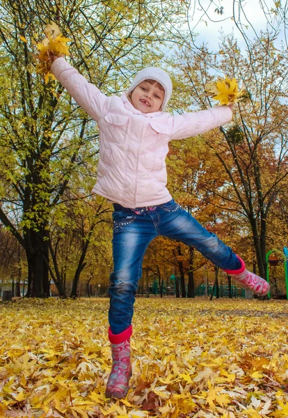 Meisje met plezier met herfst bladeren — Stockfoto