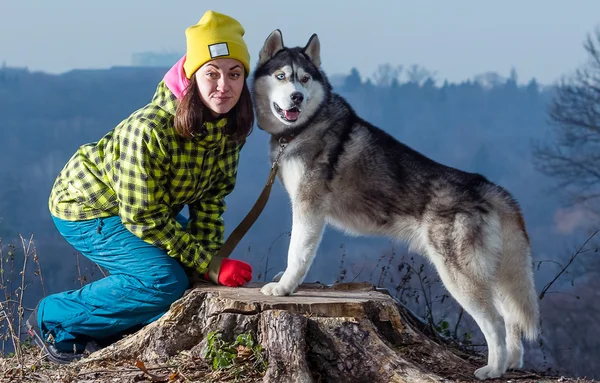 Mädchen sitzt mit Husky-Hund in den Bergen — Stockfoto