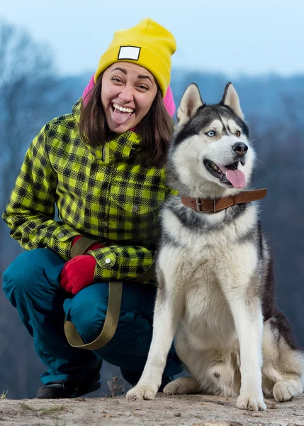 Mädchen sitzt mit Husky-Hund in den Bergen — Stockfoto