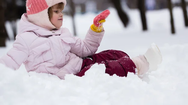 Kind in de winter. meisje rollen beneden de heuvels — Stockfoto