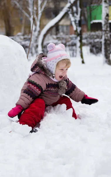 Kind in de winter. meisje rollen beneden de heuvels — Stockfoto