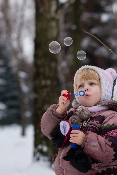 Meisje met zeep bubles in de winter — Stockfoto